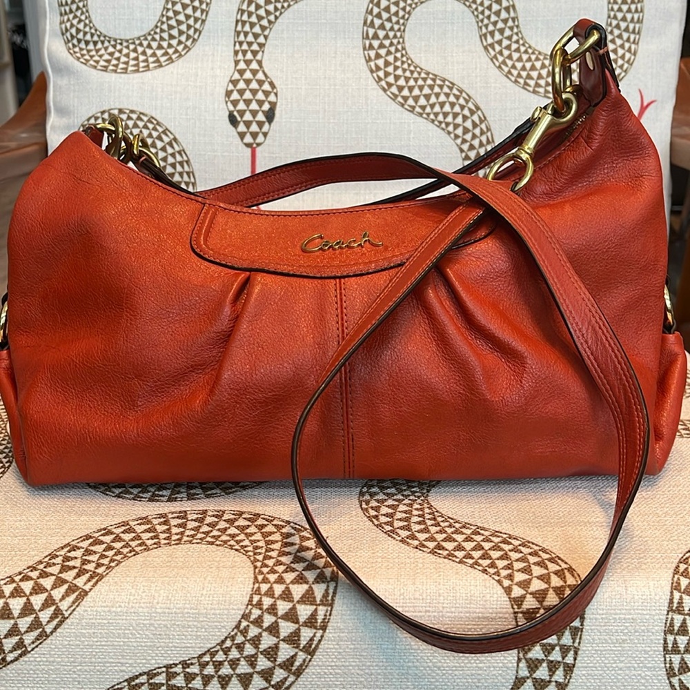Orange Coach hobo-style handbag with gold hardware